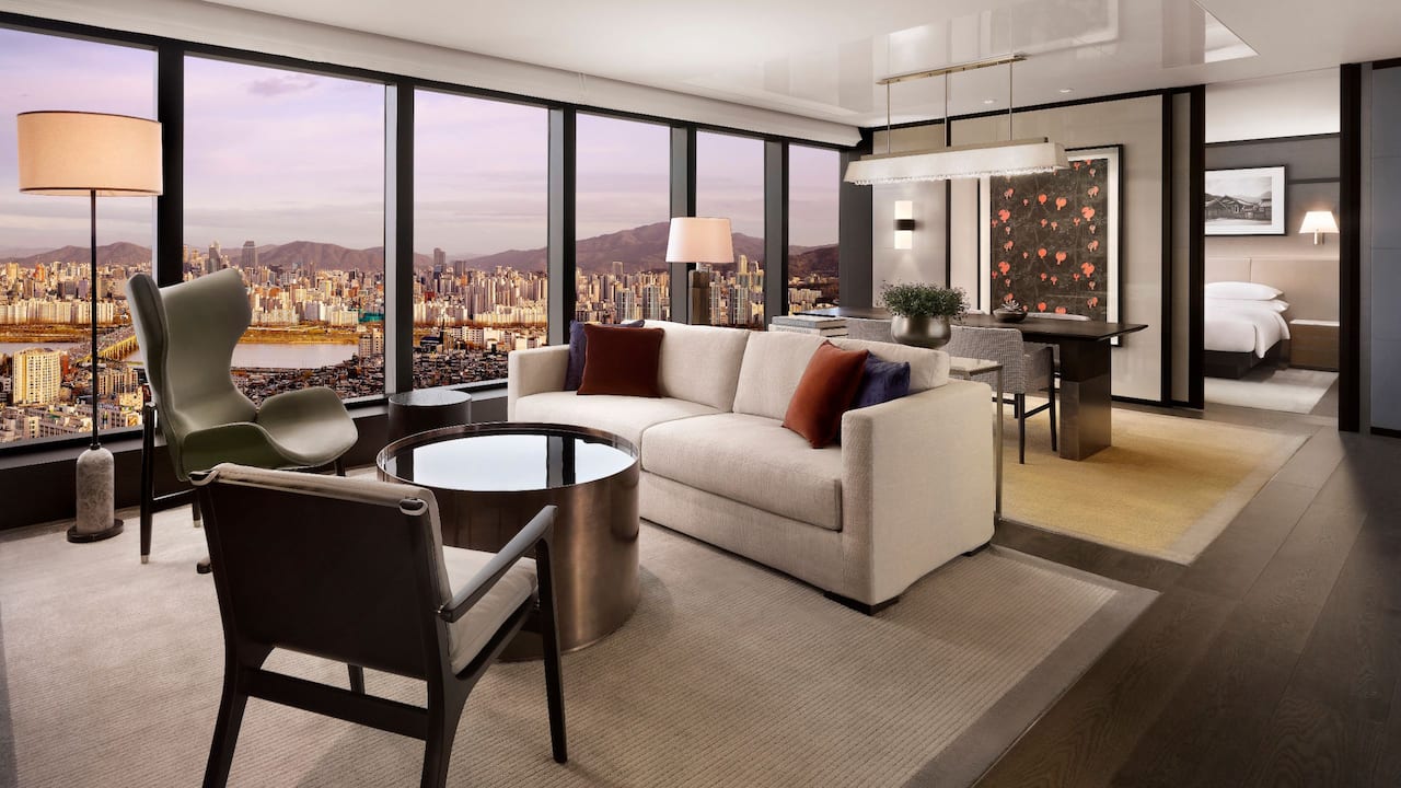 A suite at the Grand Hyatt Seoul, floor-to-ceiling windows looking out over the city at dusk